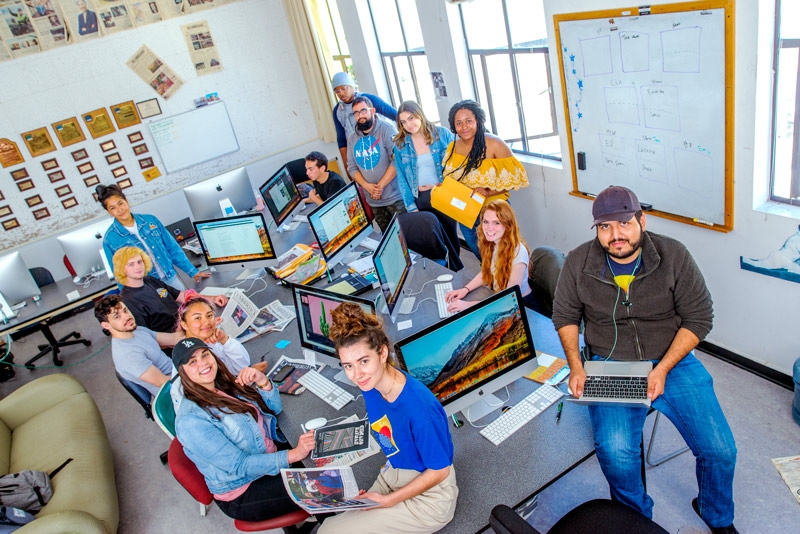 a group of journalism students in a room with computers - view from above